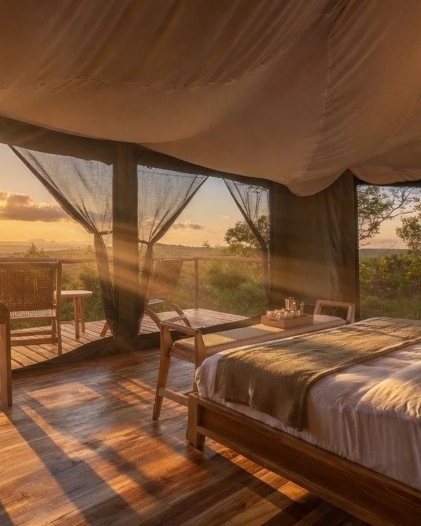 Safari tent interior at Zuri Camps with sunrise over the Serengeti